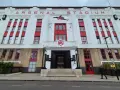 Dawny stadion Arsenalu w Highbury, z charakterystycznym napisem "ARSENAL STADIUM" i czerwonymi akcentami.