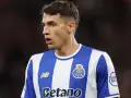 Piłkarz w niebiesko-białej koszulce FC Porto, gdzie gra Kiwior, z uwagą obserwuje boisko.