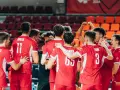 Siatkówka polska czechy: młodzi zawodnicy w czerwonych strojach świętują zwycięstwo, otoczeni kolegami z drużyny.