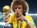 Piłkarz z Brazylii, z bujną fryzurą, triumfalnie trzyma złoty puchar Konfederacji FIFA.