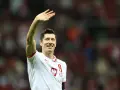 Robert Lewandowski w koszulce reprezentacji Polski z numerem 9, macha do kibiców.