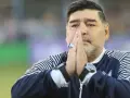 Diego Maradona na co zmarł? Legenda futbolu z dłońmi złożonymi do modlitwy, w charakterystycznej bluzie.