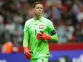 Wojciech Szczęsny, bramkarz reprezentacji Polski, w zielonej koszulce i pomarańczowych rękawicach. Jego imponujący wzrost pozwala mu skutecznie bronić.