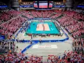 Widownia Ergo Areny, wypełniona kibicami z flagami Polski, dopingująca mecz siatkówki. Ogromna pojemność hali robi wrażenie.