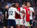 Piłkarze Arsenalu i Tottenhamu w gorącej dyskusji z sędzią. To właśnie co to są derby w piłce nożnej – mecze pełne emocji i napięcia.