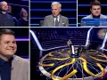Uczestnik teleturnieju "Milionerzy" odpowiada na pytanie o walutę i klub piłkarski. W tle widzowie i prowadzący.