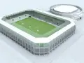 Nowoczesny stadion RKS Radomiak Radom z zieloną murawą i trybunami. Obok okrągły budynek.