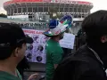 Tłum ludzi przed stadionem Azteca. Na pierwszym planie mężczyzna w meksykańskim kapeluszu, obok baner z portretami zaginionych.