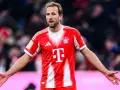 Piłkarz Harry Kane w czerwonej koszulce Bayernu Monachium, zastanawia się, ile zarabia.
