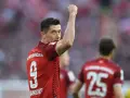 Piłkarz Robert Lewandowski w czerwonej koszulce z numerem 9 świętuje bramkę.