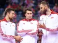 Trzech siatkarzy w strojach z biało-czerwoną flagą Polski. Jeden z nich trzyma puchar, symbolizujący, kto jest aktualnym mistrzem świata w siatkówce.
