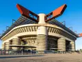 San Siro, ikona Mediolanu, czeka na wyburzenie. Monumentalna konstrukcja stadionu z czerwonymi elementami dachu i betonowymi filarami.