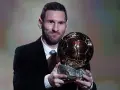 Lionel Messi, który dostał Złotą Piłkę, prezentuje trofeum.