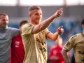 Uśmiechnięty Lukas Podolski pokazuje kciuk w górę, jakby podsumowywał swoje świetne statystyki.