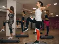 Kobiety na stepach wykonują trening aerobowy co to jest, ćwicząc równowagę i kondycję.