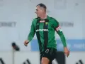 Piłkarz Górnika Łęczna w zielono-czarnej koszulce z opaską kapitana. Mecz z GKS Tychy.