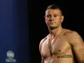 KSW relacja: Muskularny zawodnik MMA z tatuażem na klatce piersiowej pozuje przed kamerą.