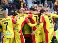 Piłkarze Korony Kielce świętują zwycięstwo nad Górnikiem Zabrze. Radość i okrzyki na boisku, kibice na trybunach.