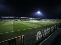 Piłkarze na murawie stadionu Górnik Łęczna, oświetlonego jupiterami.