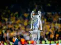 Trofeum Ligi Mistrzów na podium, z tłumem kibiców w tle. Zastanawiasz się, ile za wygranie ligi mistrzów?