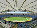 Pusta Marakana, stadion w Rio de Janeiro, z zieloną murawą i żółto-niebieskimi siedzeniami pod białym dachem.