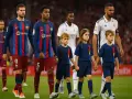 Dzieci wyprowadzają piłkarzy na boisko. Mali kibice towarzyszą zawodnikom FC Barcelony i Realu Madryt, tworząc wyjątkową atmosferę przed meczem.