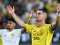 Cristiano Ronaldo w żółtej koszulce z podniesionymi rękami. Ile goli strzelił Ronaldo?