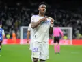 Vinicius Jr. w białej koszulce Realu Madryt z numerem 20, świętuje bramkę na tle trybun.