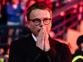Właściciel Wisły Kraków, w okularach, z rękami złożonymi do modlitwy, wpatruje się w dal.