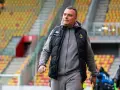 Mężczyzna w kamizelce Jagiellonii, być może omawia nowe jagiellonia transfery na tle pustych trybun stadionu.