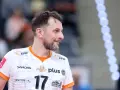 Uśmiechnięty rozgrywający w siatkówce, z numerem 17 na koszulce, gotowy do gry.