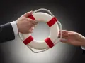 Dłoń podaje koło ratunkowe, symbolizujące zakład bezpieczny STS. Pomoc w trudnej sytuacji.