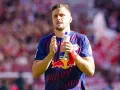 Piłkarz w koszulce RB Leipzig, jeden z zawodników 2. Bundesligi, trzyma butelkę z napojem.