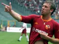 Antonio Cassano w koszulce Romy, z palcem wskazującym w górę, celebruje bramkę.