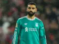 Mohamed Salah w zielonej koszulce Liverpoolu, symbol jego obecności w klubie, która jest kluczowa dla transferów Liverpool.