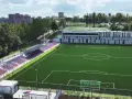 Nowy stadion Polonii Bytom z zieloną murawą, trybunami w kolorach czerwonym i niebieskim oraz nowoczesnym budynkiem klubowym.