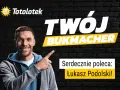 Uśmiechnięty mężczyzna wskazuje na napis "Twój Bukmacher". Totolotek poleca Łukasza Podolskiego do zakładów bukmacherskich.