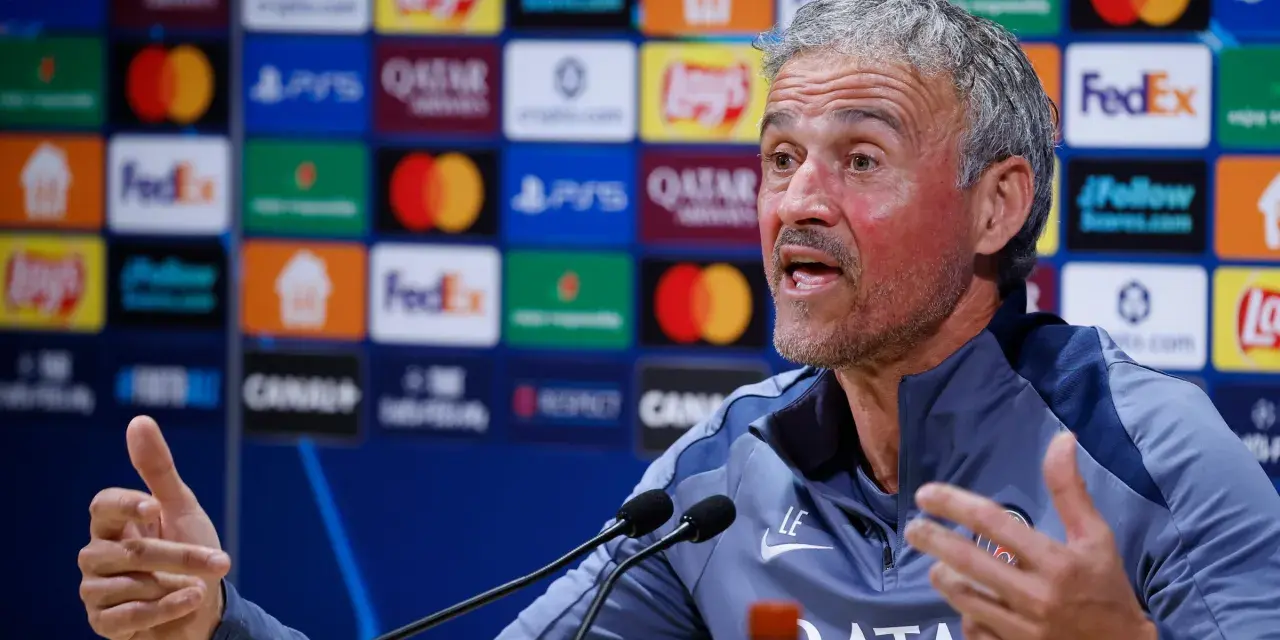 Luis Enrique, trener PSG, z pasją opowiada o tym, kto wygra Ligę Mistrzów, gestykulując przed mikrofonami.