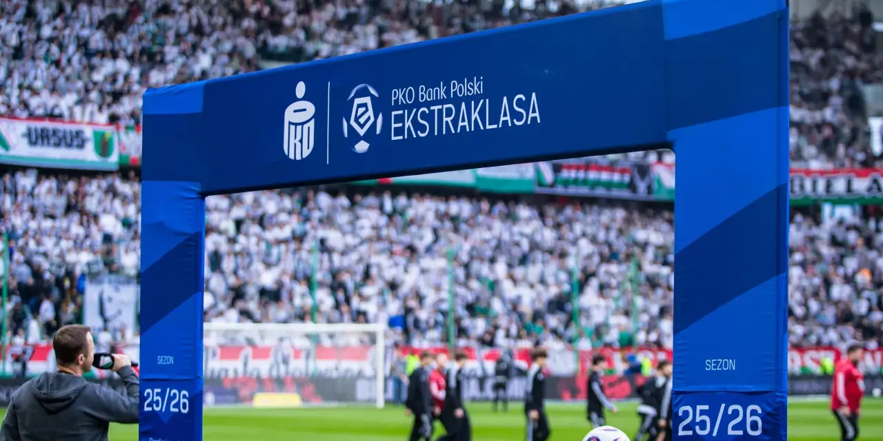 Brama z logo PKO Bank Polski Ekstraklasa na tle stadionu i kibiców. Sezon 25/26.