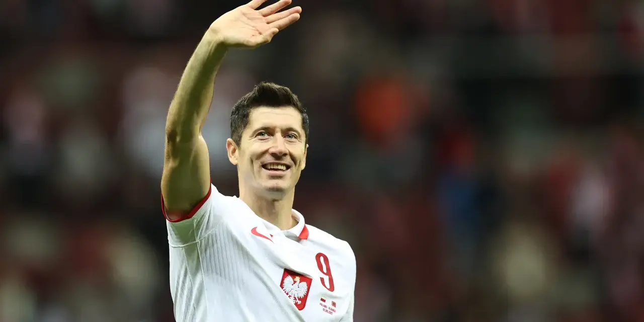 Robert Lewandowski w koszulce reprezentacji Polski z numerem 9, macha do kibiców.
