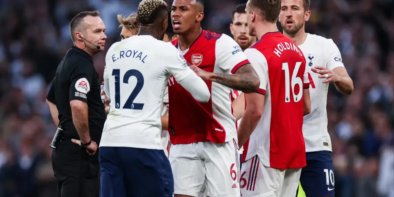 Piłkarze Arsenalu i Tottenhamu w gorącej dyskusji z sędzią. To właśnie co to są derby w piłce nożnej – mecze pełne emocji i napięcia.