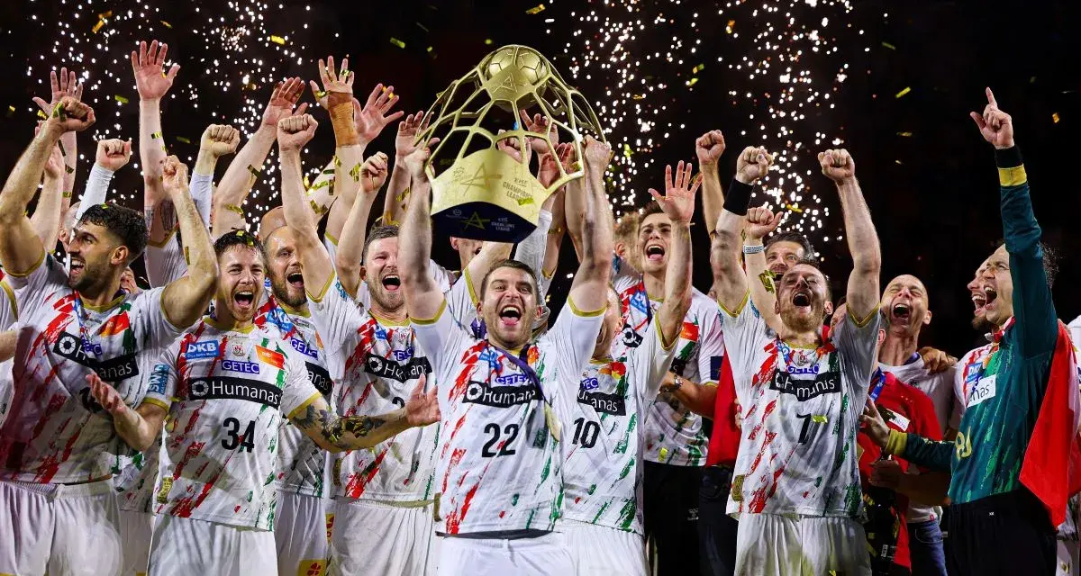 Drużyna świętuje zwycięstwo w finale piłki ręcznej, unosząc puchar. Konfetti i fajerwerki podkreślają radość.