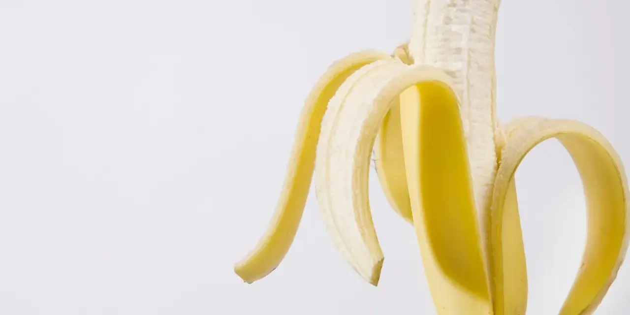 Połówka obranego banana, idealna przekąska przed czy po treningu, dostarcza energii.