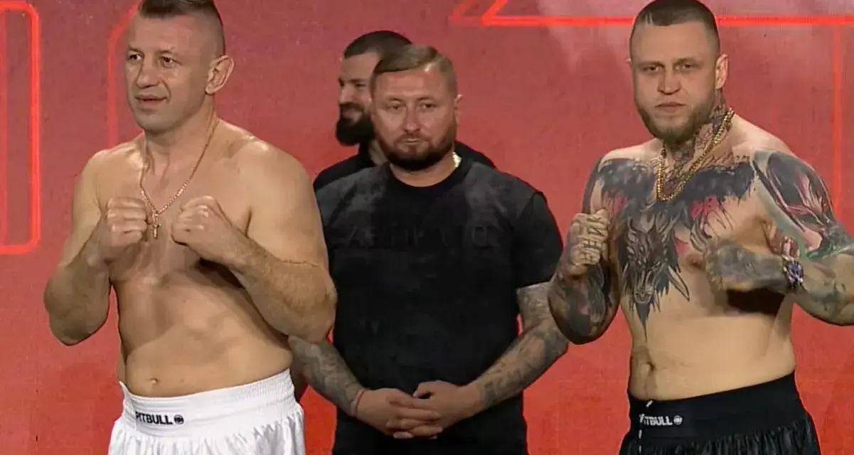Dwóch zawodników MMA, jeden z tatuażami na klatce piersiowej, gotowych do walki. W tle stoi mężczyzna.