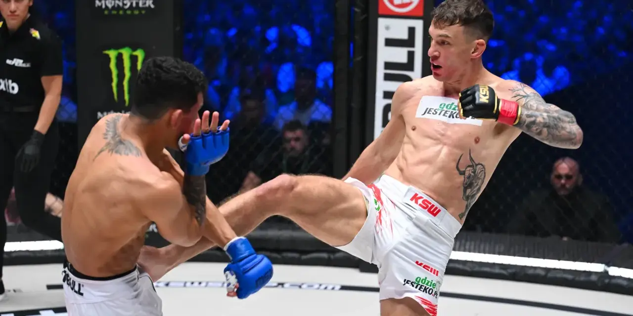 Zacięta walka na KSW 115 karta walk. Zawodnik w białych spodenkach wykonuje wysokie kopnięcie, przeciwnik blokuje je rękawicą.
