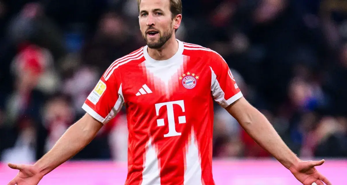 Piłkarz Harry Kane w czerwonej koszulce Bayernu Monachium, zastanawia się, ile zarabia.