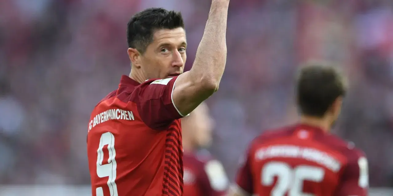 Piłkarz Robert Lewandowski w czerwonej koszulce z numerem 9 świętuje bramkę.