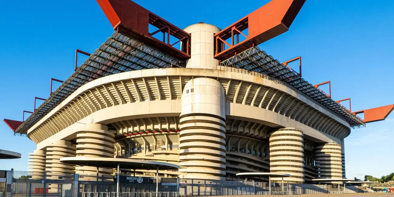 San Siro, ikona Mediolanu, czeka na wyburzenie. Monumentalna konstrukcja stadionu z czerwonymi elementami dachu i betonowymi filarami.