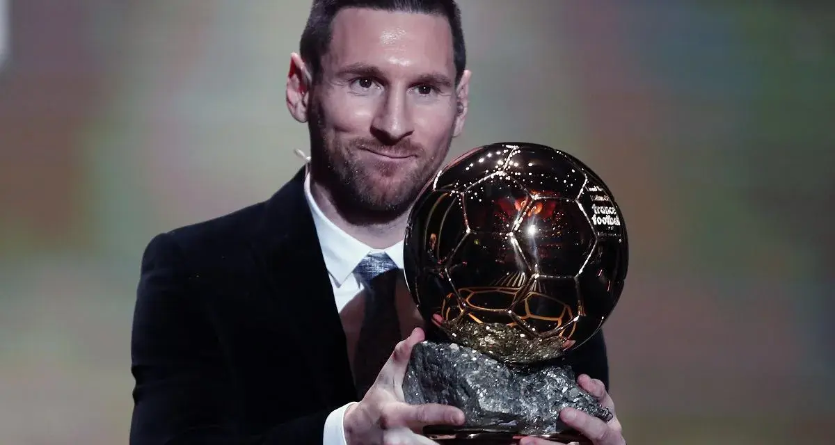 Lionel Messi, który dostał Złotą Piłkę, prezentuje trofeum.