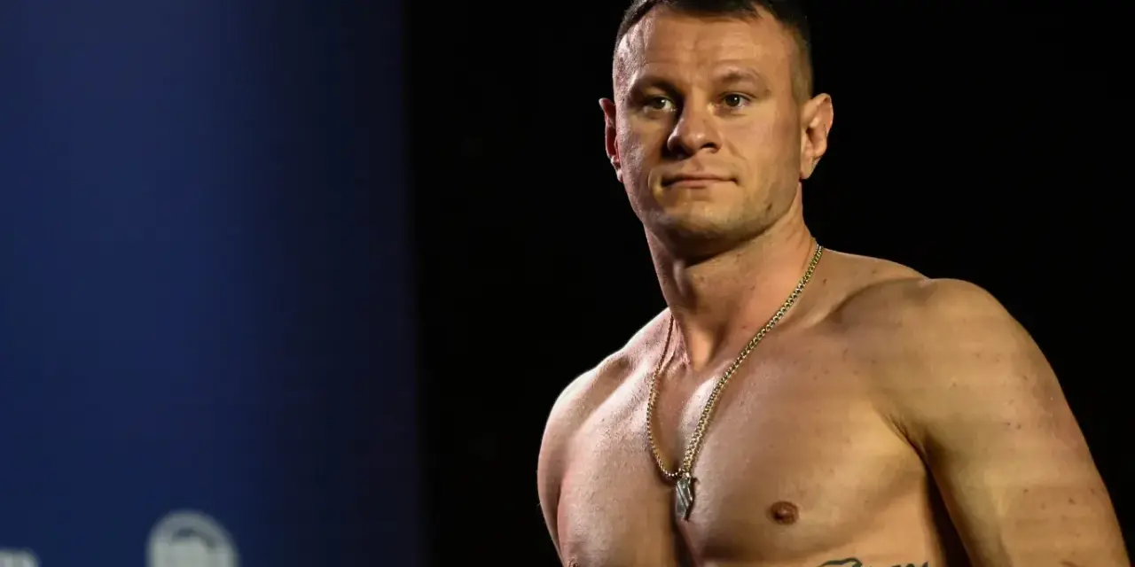 KSW relacja: Muskularny zawodnik MMA z tatuażem na klatce piersiowej pozuje przed kamerą.
